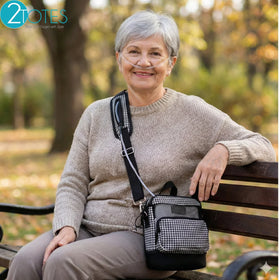 Senior woman outdoors using nasal cannula with O2TOTES Inogen One G3 carry bag on park bench